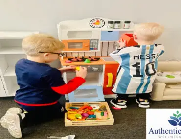 Two children playing wth toys in a room. Therapeutic Play for children.