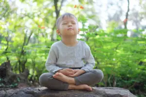 a child learning meditation techniques from experts
