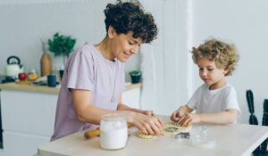 An adult and child baking together, representing a nurturing and supportive family environment for youth mental health.