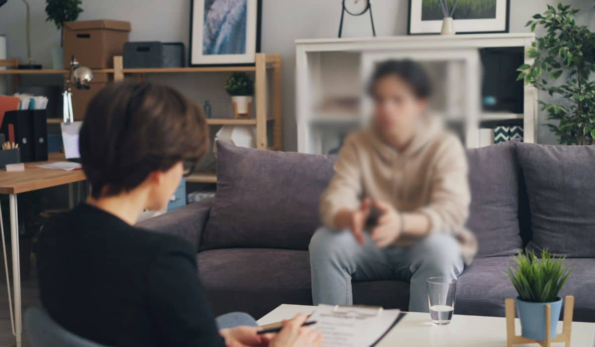 Teen in a counseling session with a therapist, seated across from each other, symbolizing therapy for struggling with anxiety.