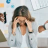 Professional woman overwhelmed at work needing stress management therapy support.