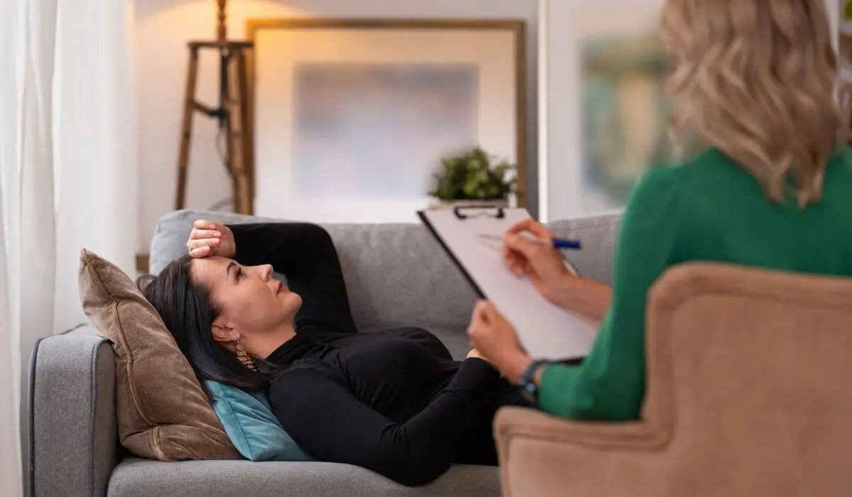 Woman experiencing physical burnout during stress management therapy session.