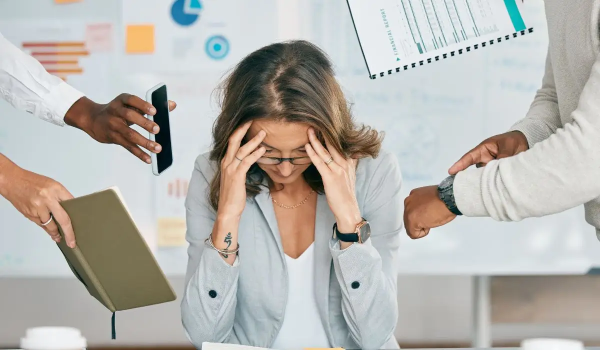 Professional woman overwhelmed at work needing stress management therapy support.